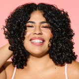 Woman smiling touching her dark curly hair